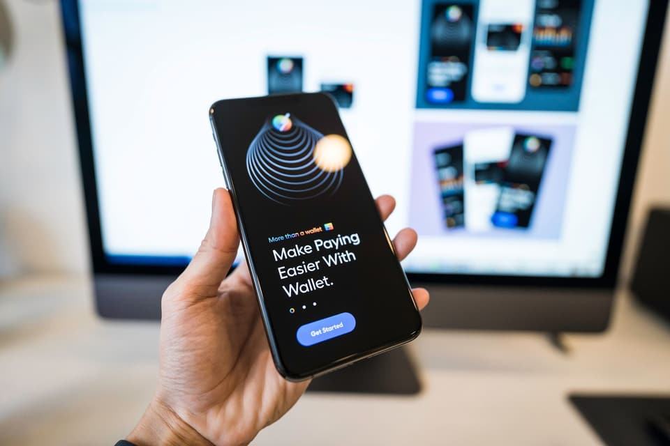 A payments-app welcome screen on a smartphone held in hand