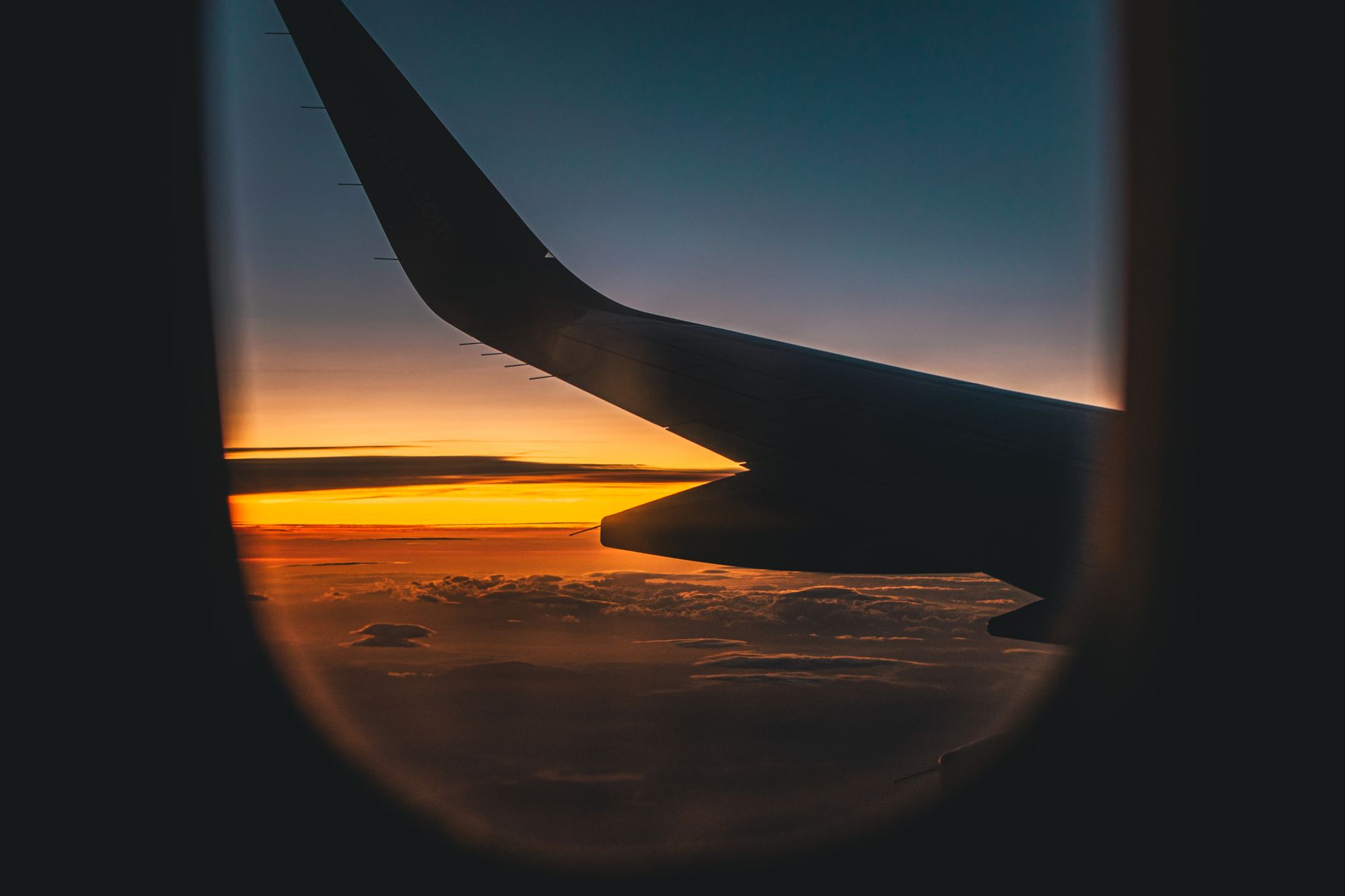 Aircraft wing above the clouds at sunrise